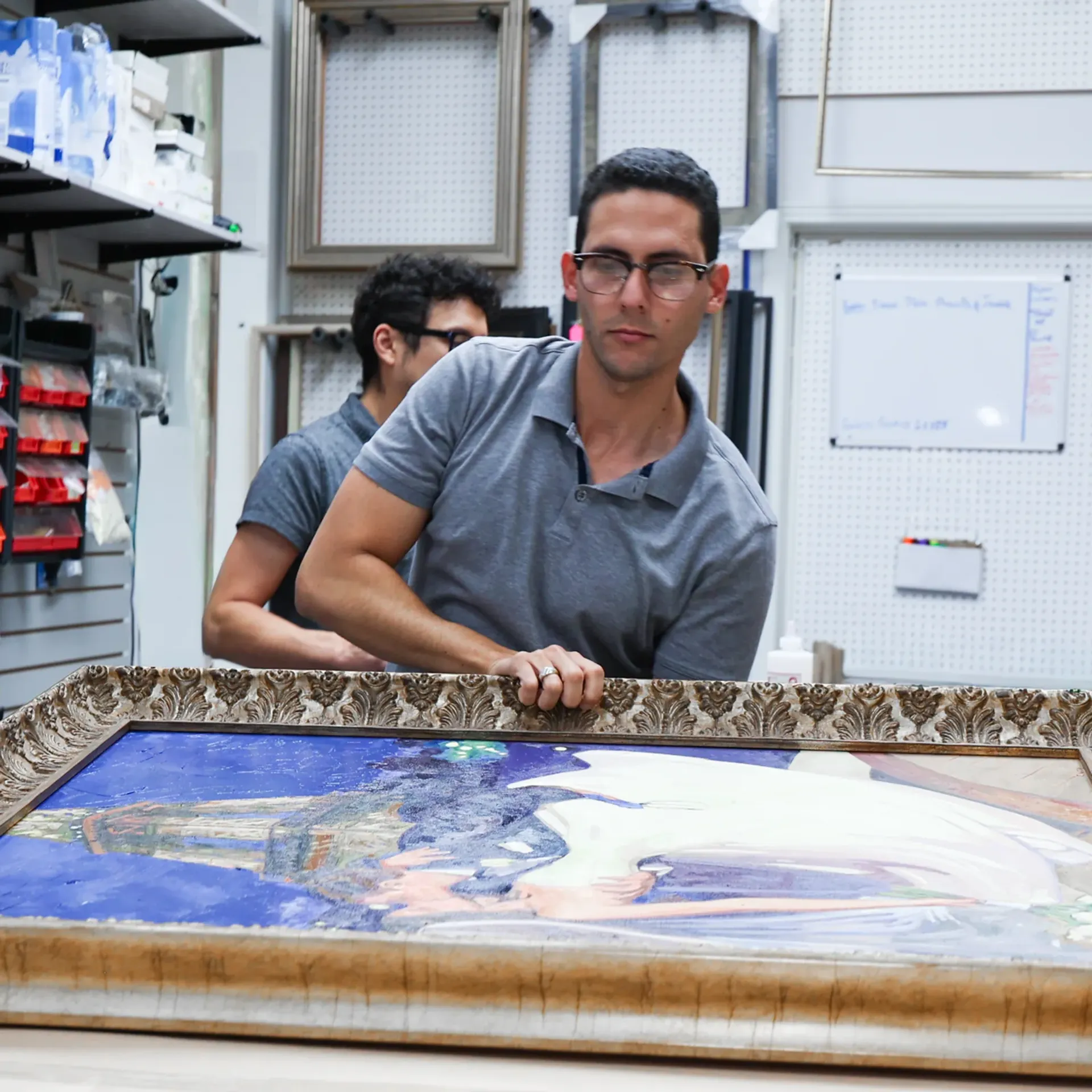 Masten framing team handling a custom framed artwork in the studio